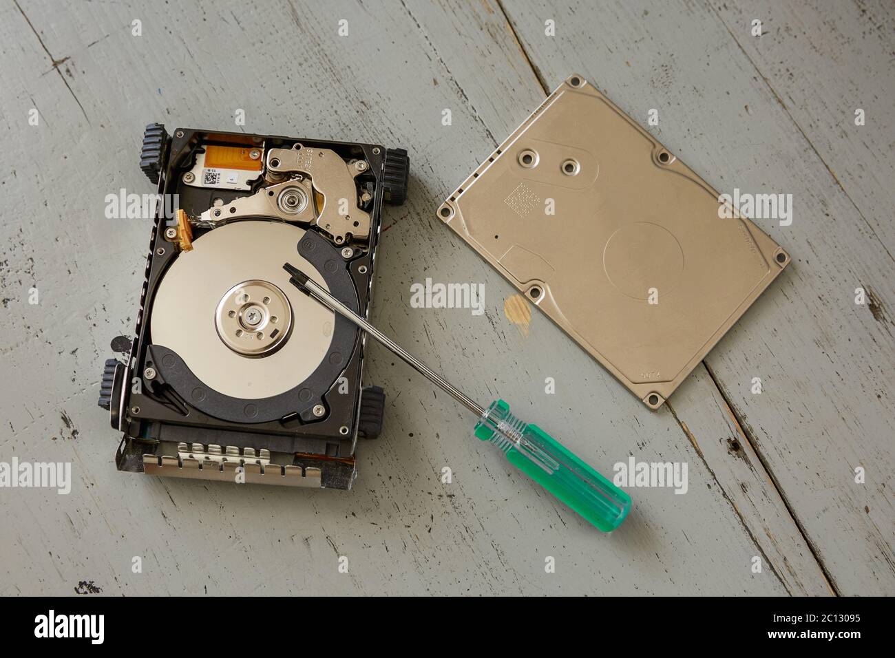 Broken and Destroyed Hard Drive Disk and Tools on Wooden Table Stock Photo