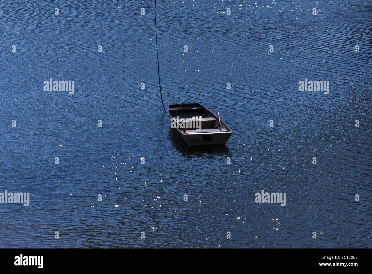 Little boat in the middle of the dam - the water in the sun shimmers Stock Photo