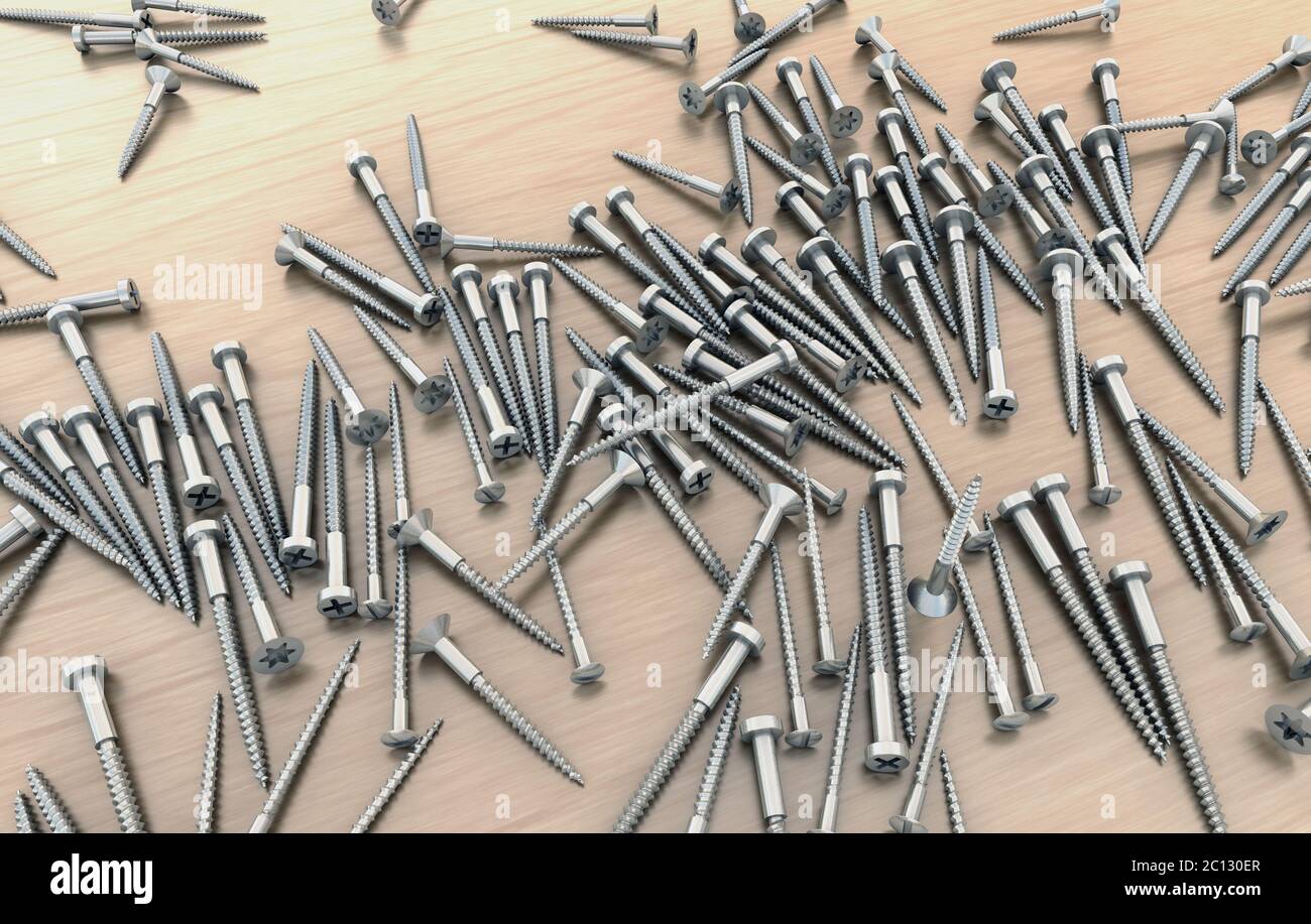 Many different metal screws on wooden table above each other Stock Photo