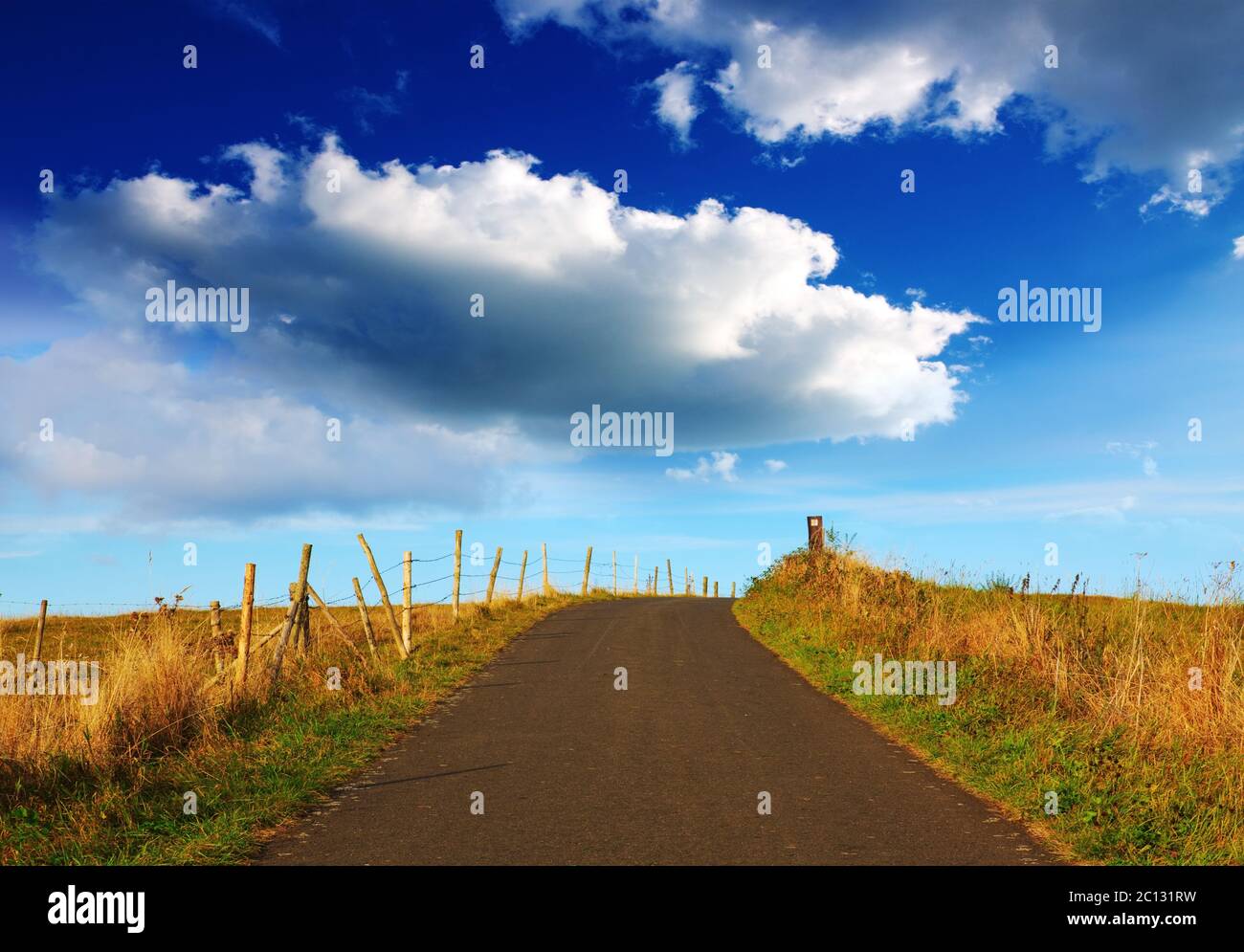 Landscape with road field and big clouds. Stock Photo