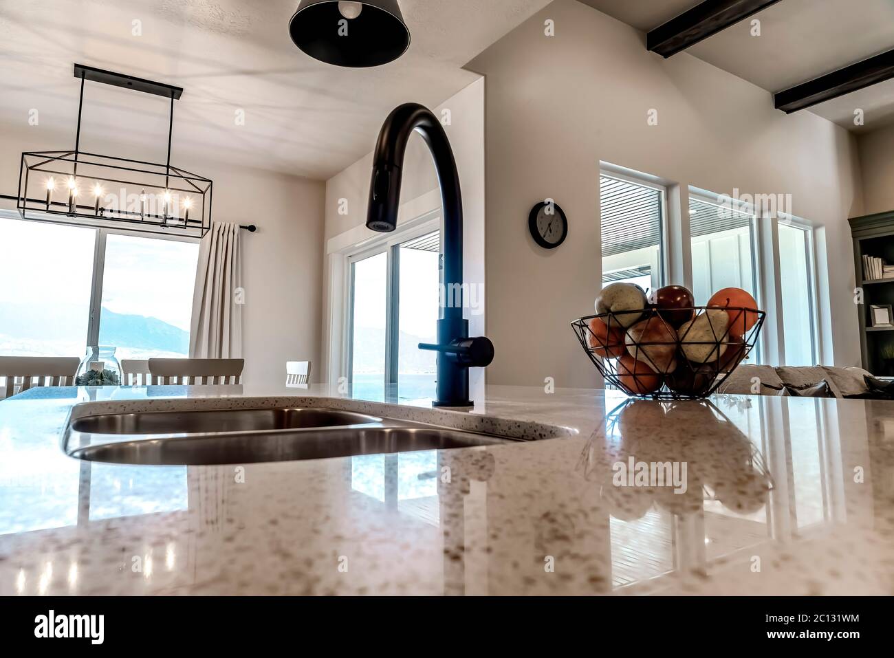 Curved Faucet Of Kitchen Island Double Sink With Fruit Basket On The Countertop Stock Photo Alamy