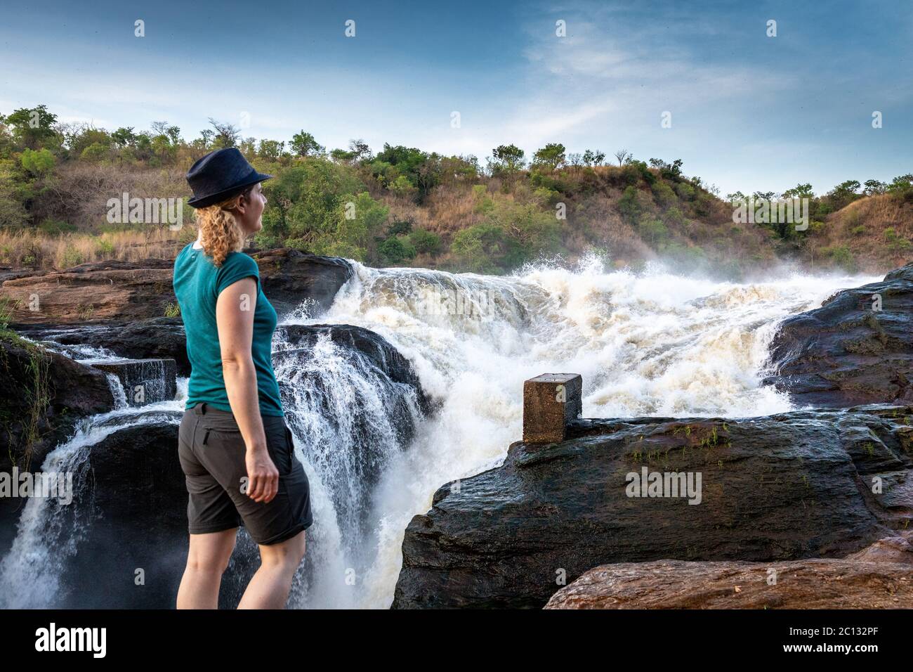A woman stands at the top of Murchison Falls  in Murchison Falls National Park, Northern Uganda, East Africa Stock Photo