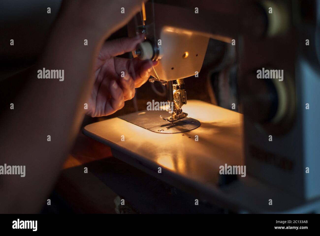 Woman's hand  working on a sewing machine Stock Photo