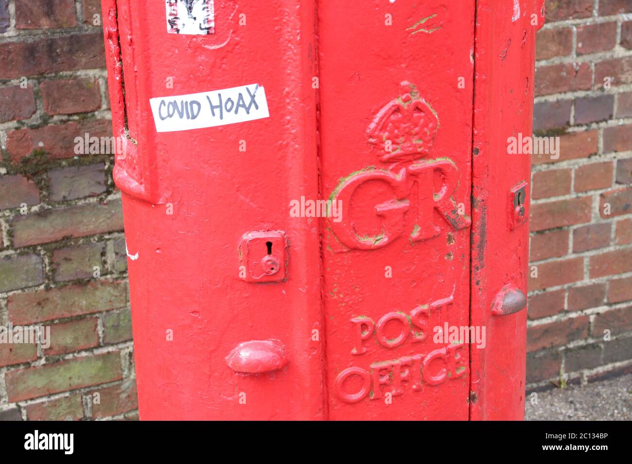 COVID HOAX GRAFFITI ON POST BOX Stock Photo