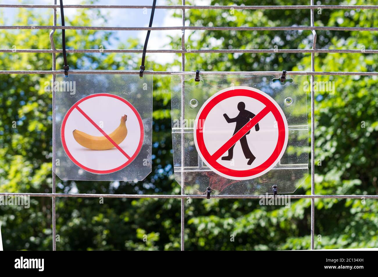 Unrecognizable persons violating the prohibition to walking and trashing. Warning. Stock Photo