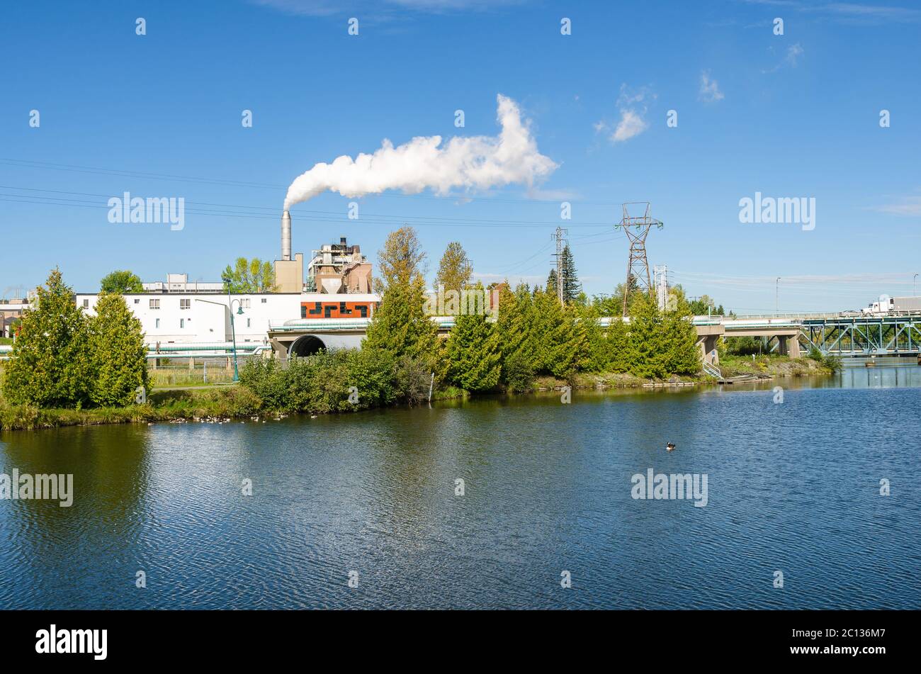 Manufacturing plant along a river on a clear early autumn day Stock Photo