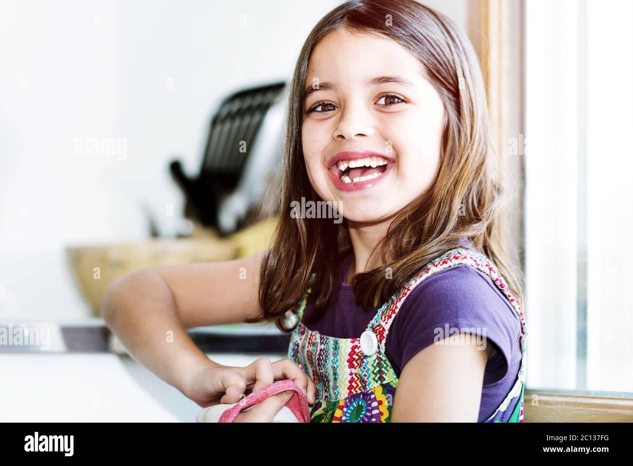 very cute kid girl wiping the dishes Stock Photo