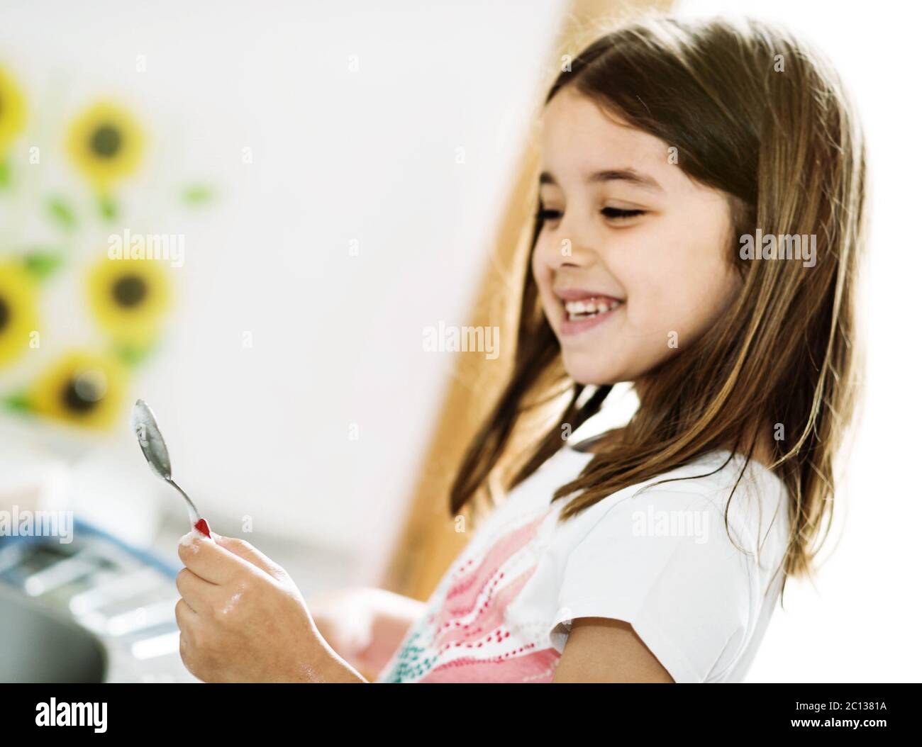 Portrait of a beautiful young girl doing crockery Stock Photo