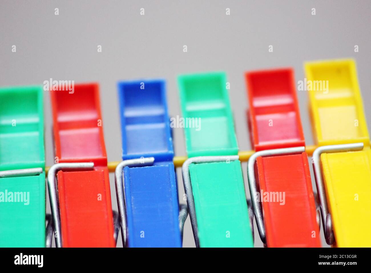 colored plastic clothespins hanging on the rope. Stock Photo