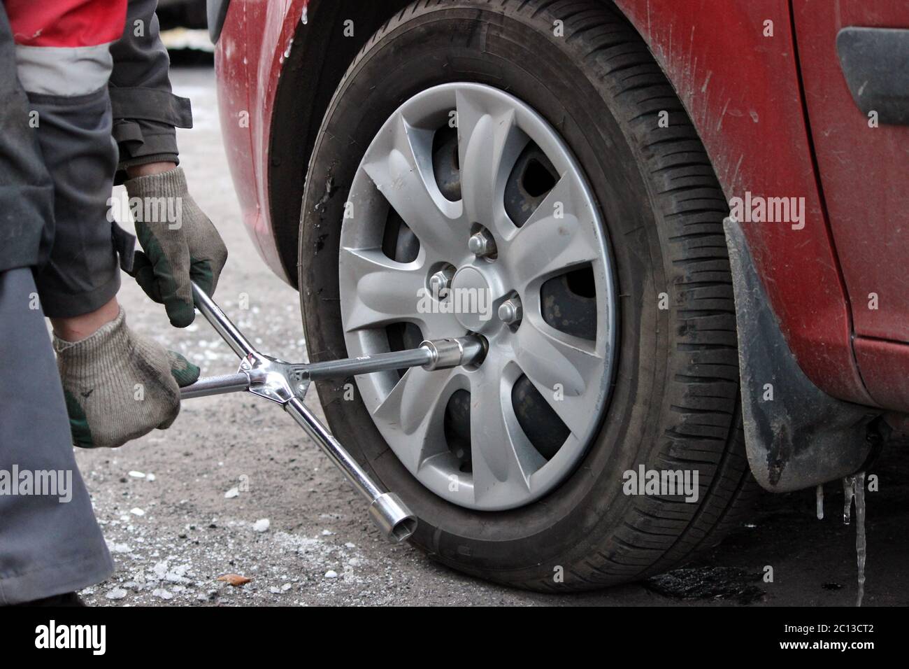 installation of passenger car wheel and replacement on winter tire. Stock Photo