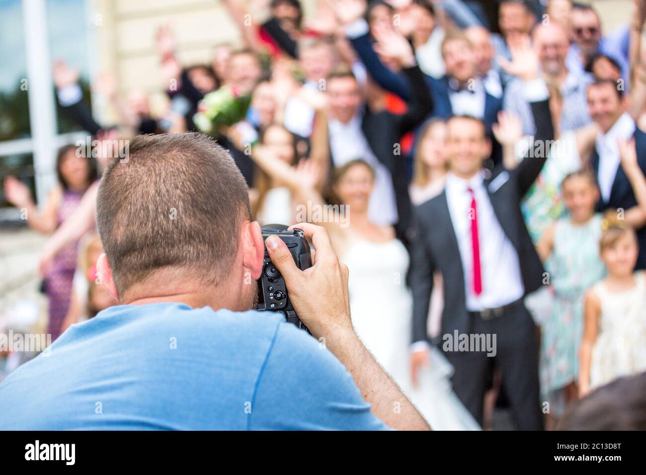 Wedding photographer in action, taking a picture of group of guests Stock Photo