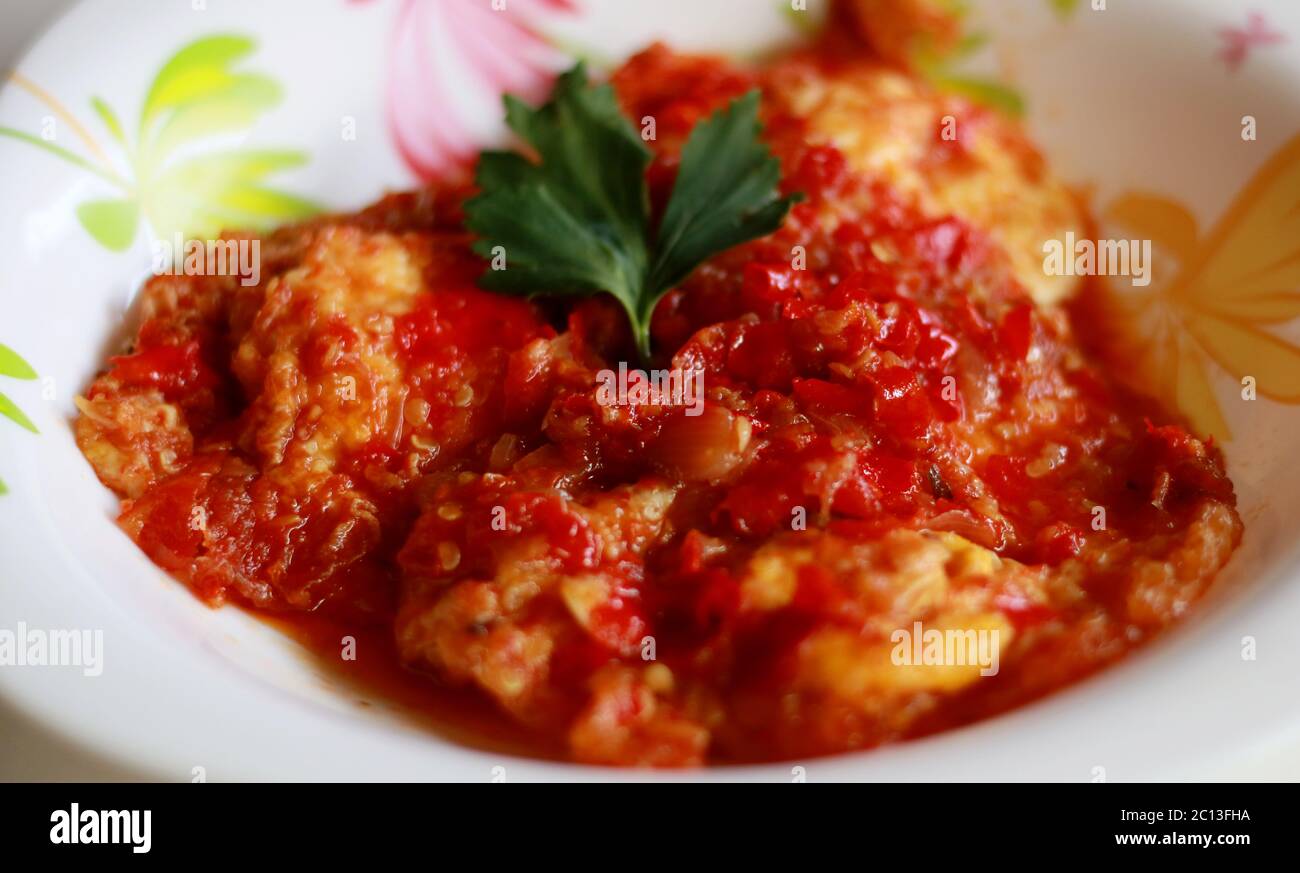 Fried egg with chili sauce. Spicy food from Indonesia. Stock Photo