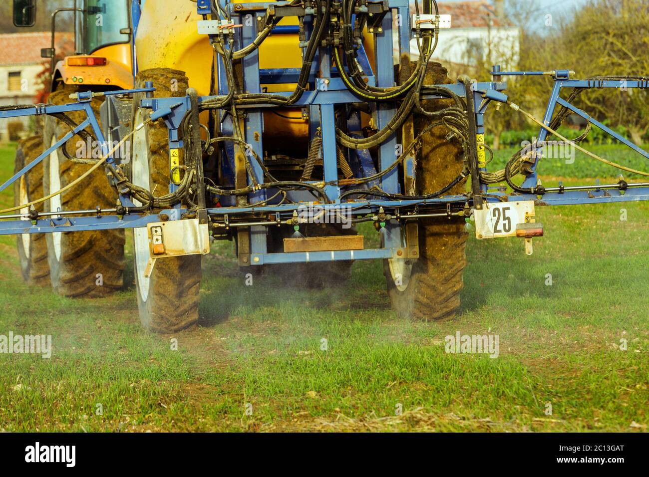 Tractor spraying wheat field with sprayer Stock Photo