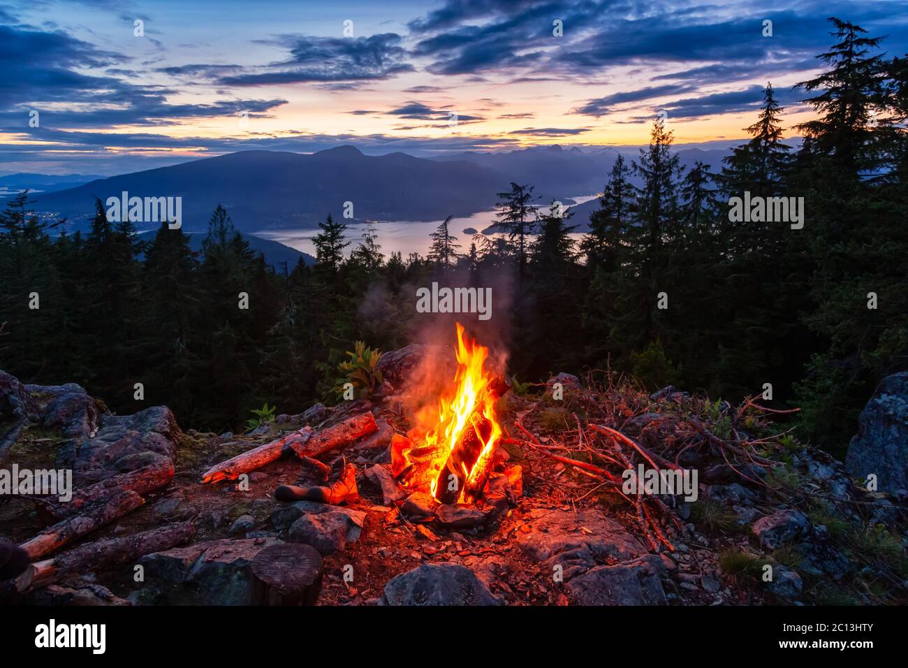 Warm Camp Fire on top of a mountain with Beautiful Canadian Nature Landscape Stock Photo