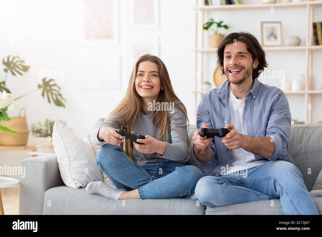 Excited funny couple playing video games at home Stock Photo