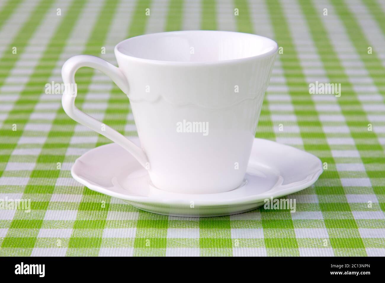 Empty cup on the checkered tablecloth Stock Photo