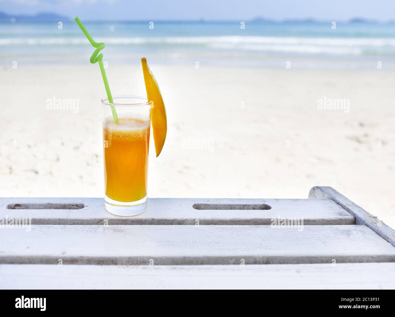 Glass of orange colour juice on the beach Stock Photo - Alamy