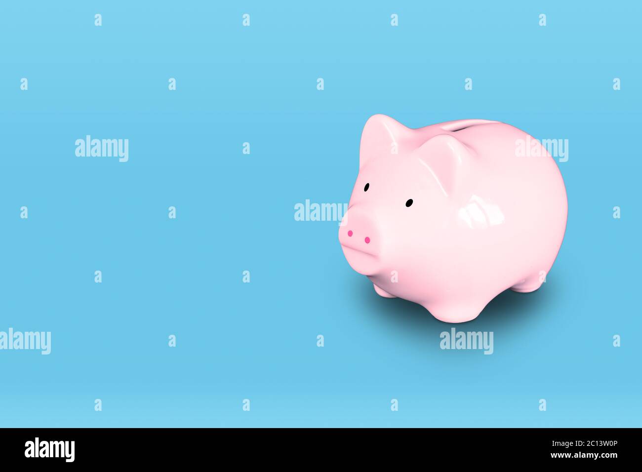 Pink piggy bank isolated on right of blue background with copy space. Stock Photo
