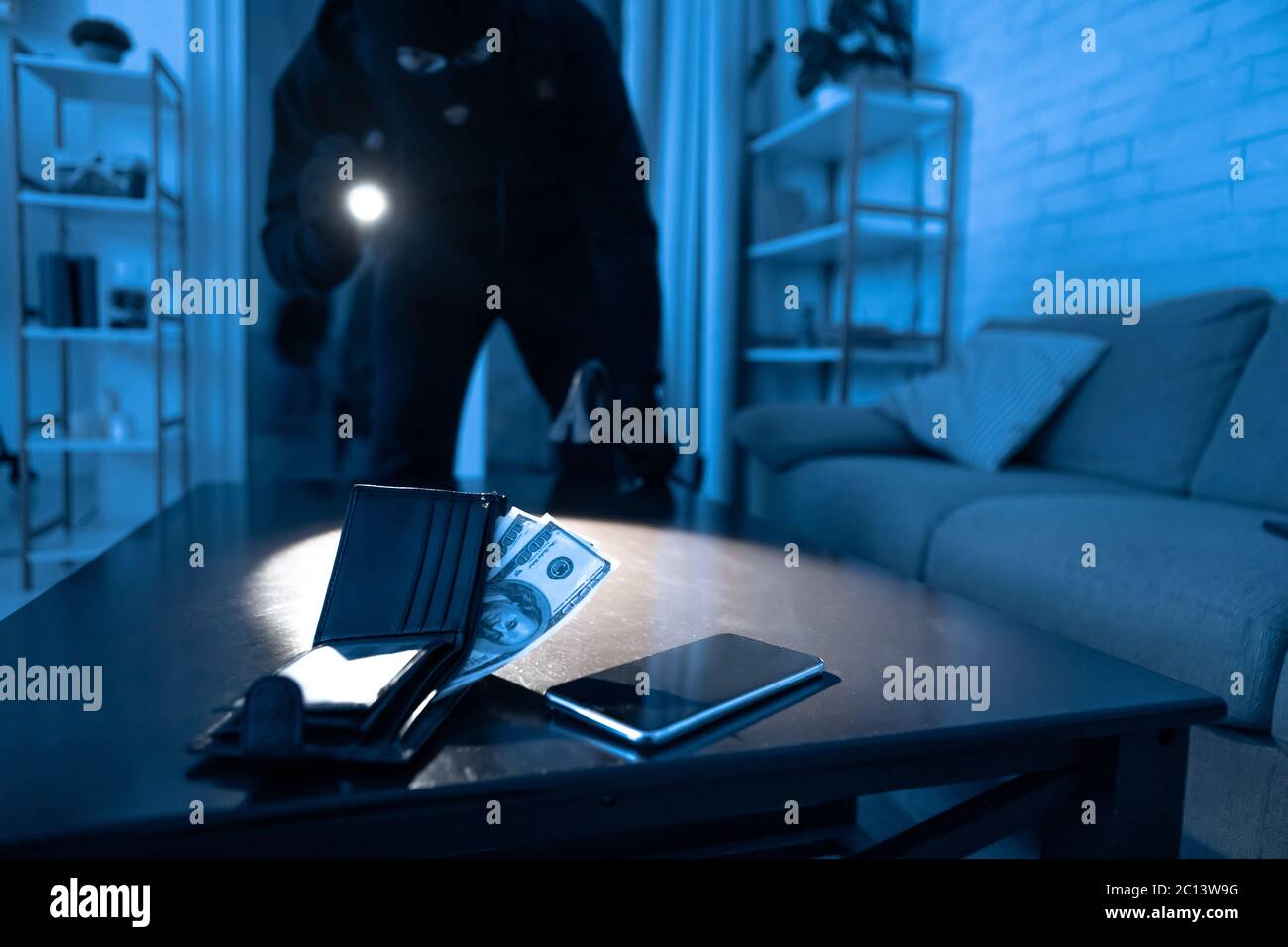 Robber breaking in an apartment ready to steal something Stock Photo