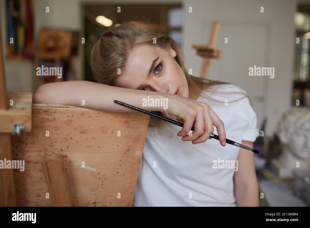 A young artist stands in a painting Studio with brushes Stock Photo - Alamy