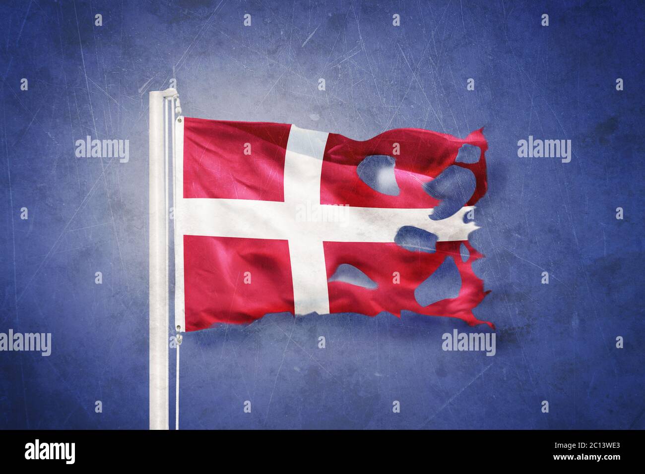 Torn flag of Denmark flying against grunge background Stock Photo