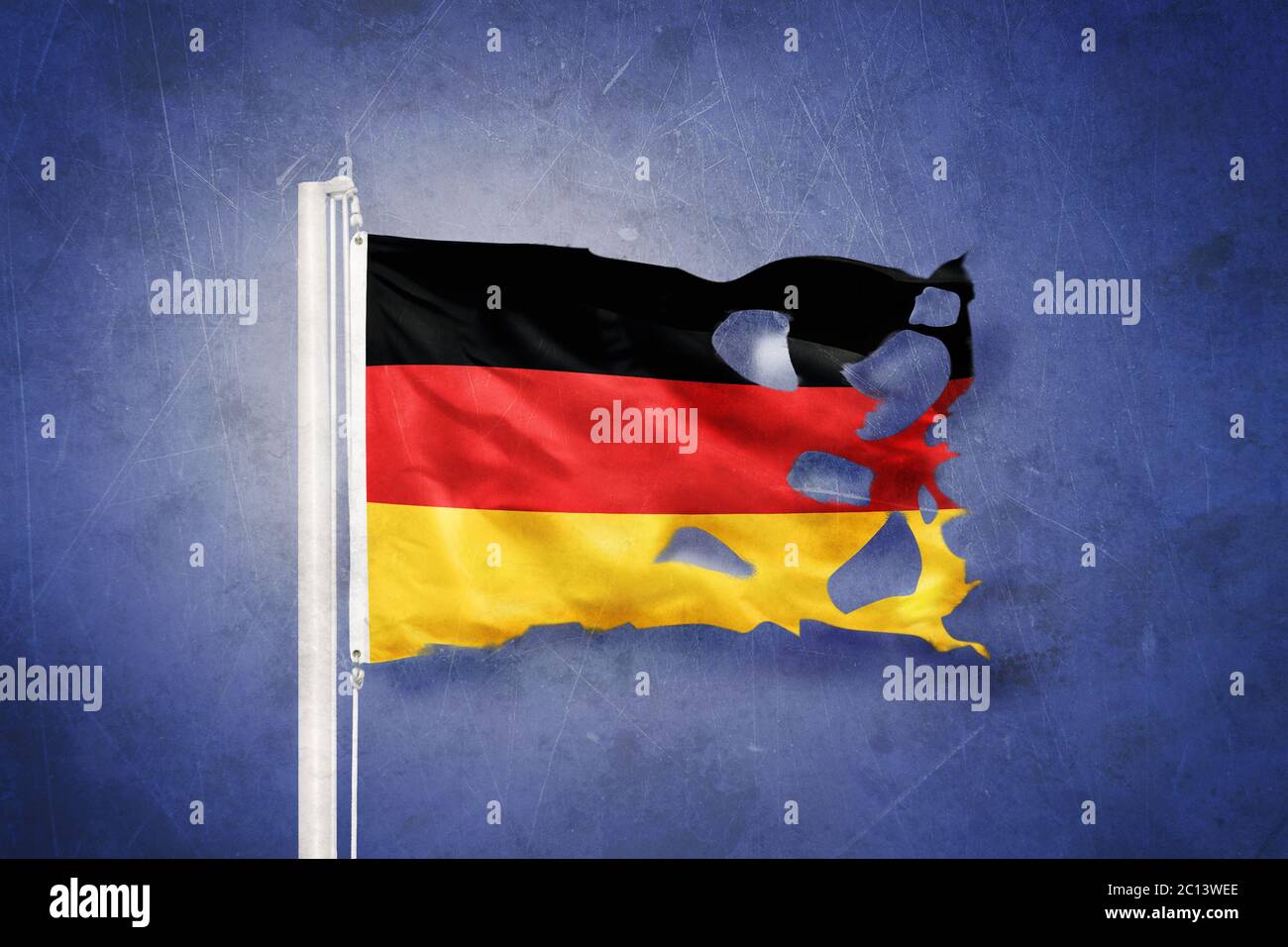 Torn flag of Germany flying against grunge background Stock Photo