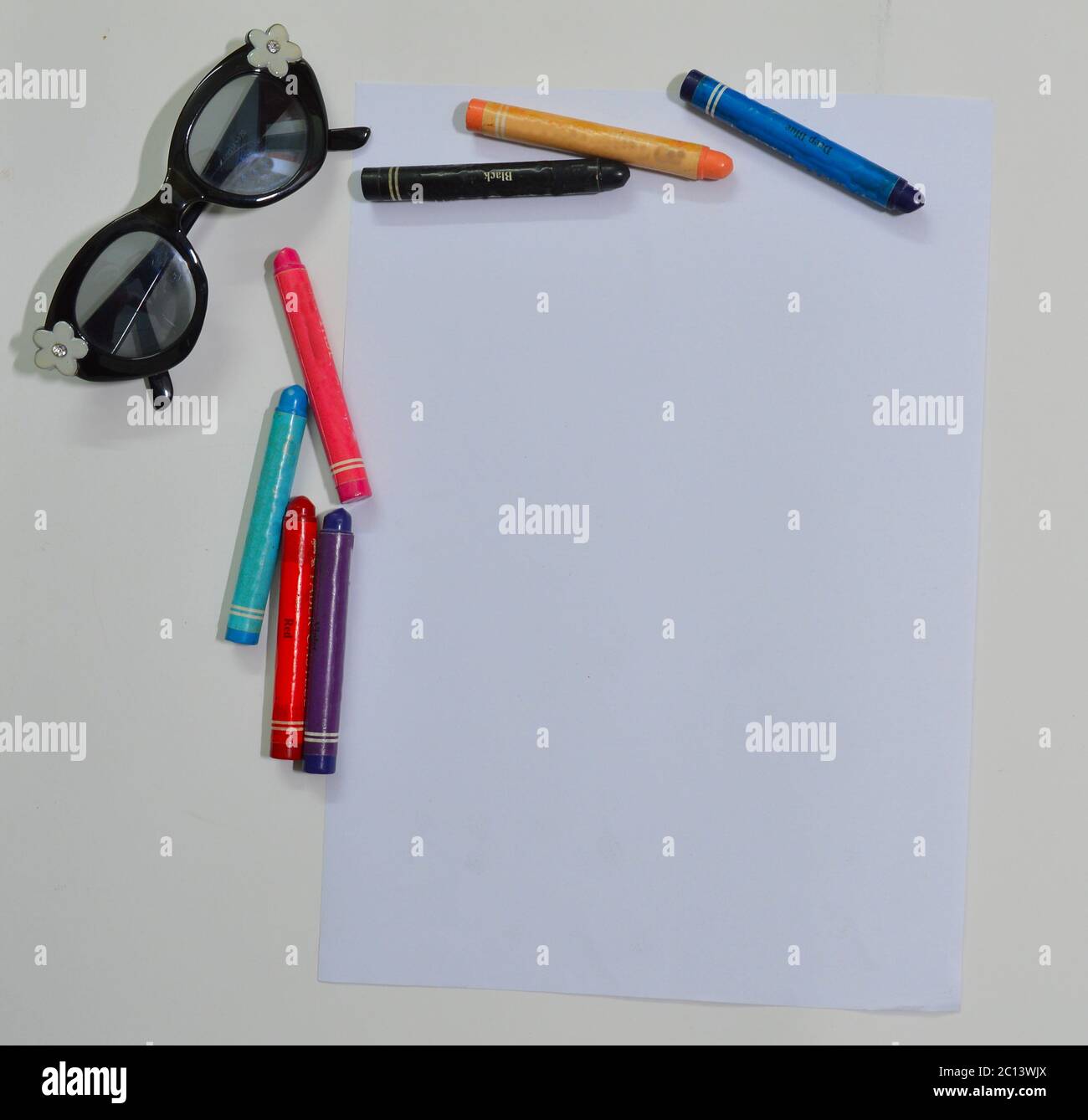 child's desk top with glasses and crayons Stock Photo