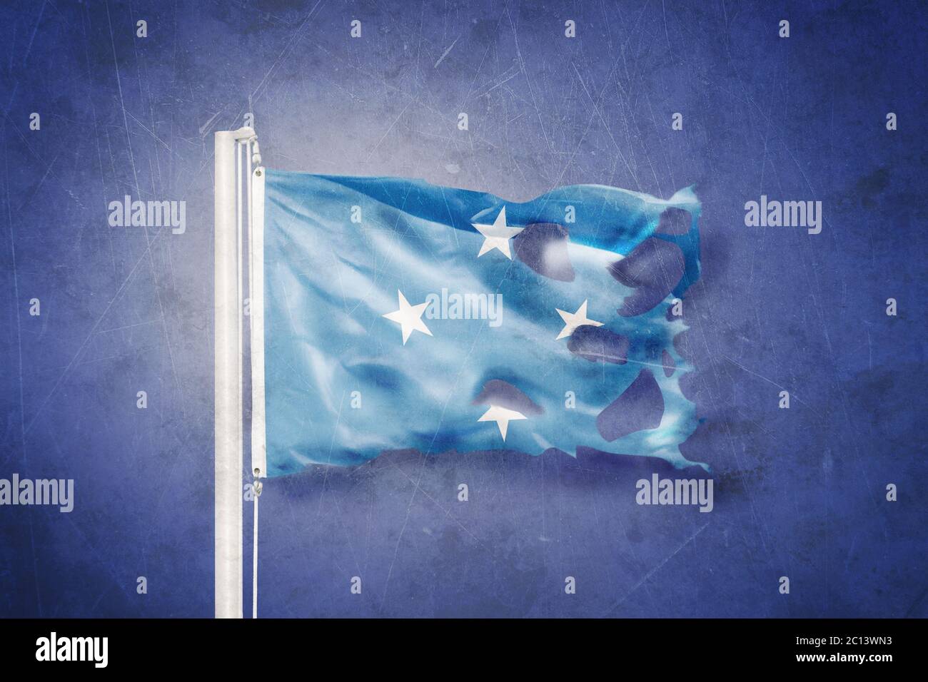 Torn flag Federated States of Micronesia flying against grunge background Stock Photo