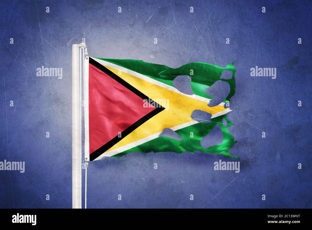 Torn flag of Guyana flying against grunge background Stock Photo