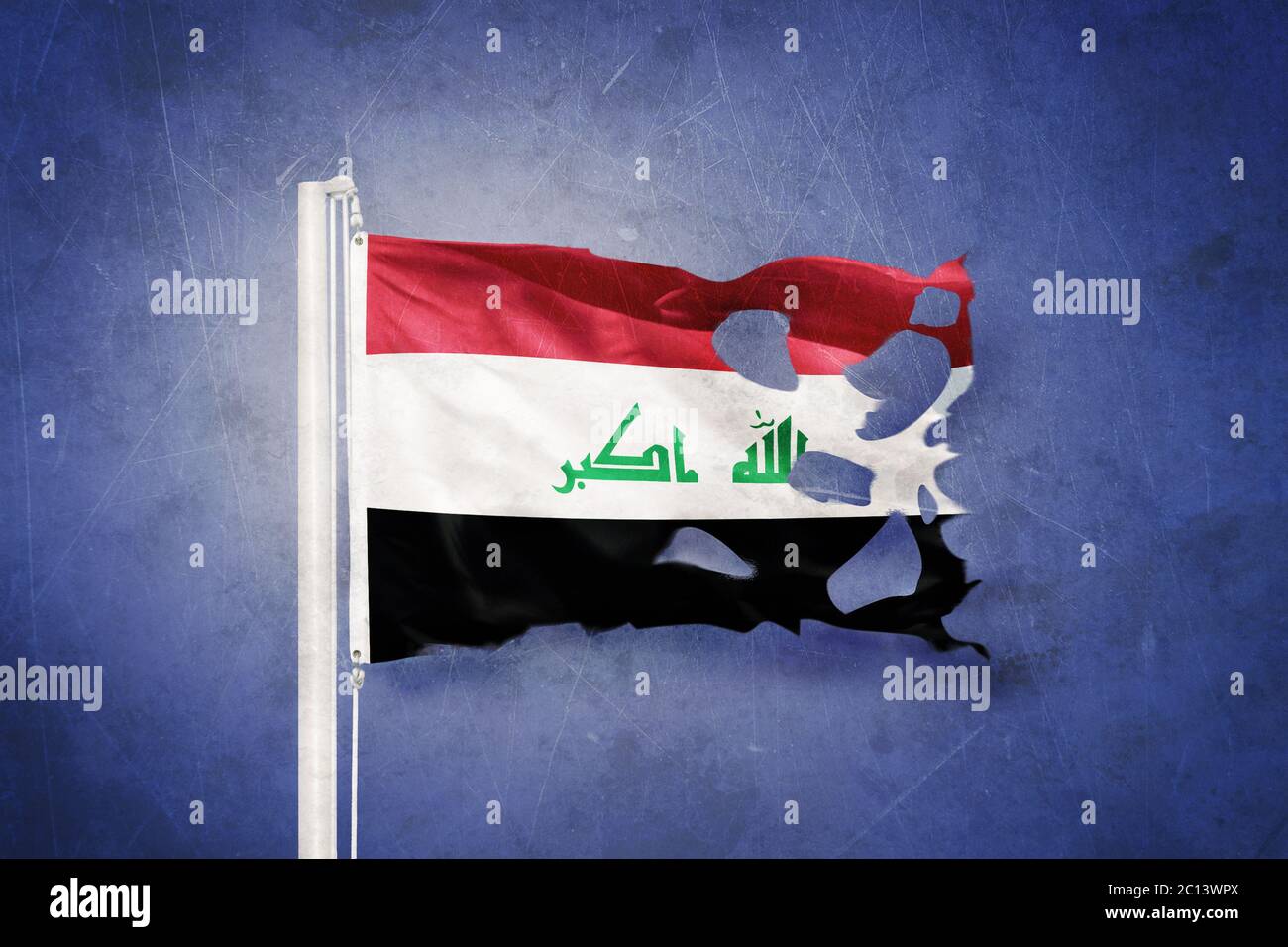 Torn flag of Iraq flying against grunge background Stock Photo