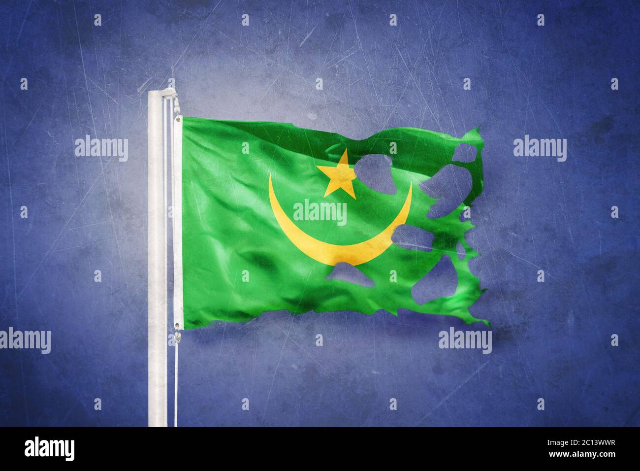 Torn flag of Mauritania flying against grunge background Stock Photo ...