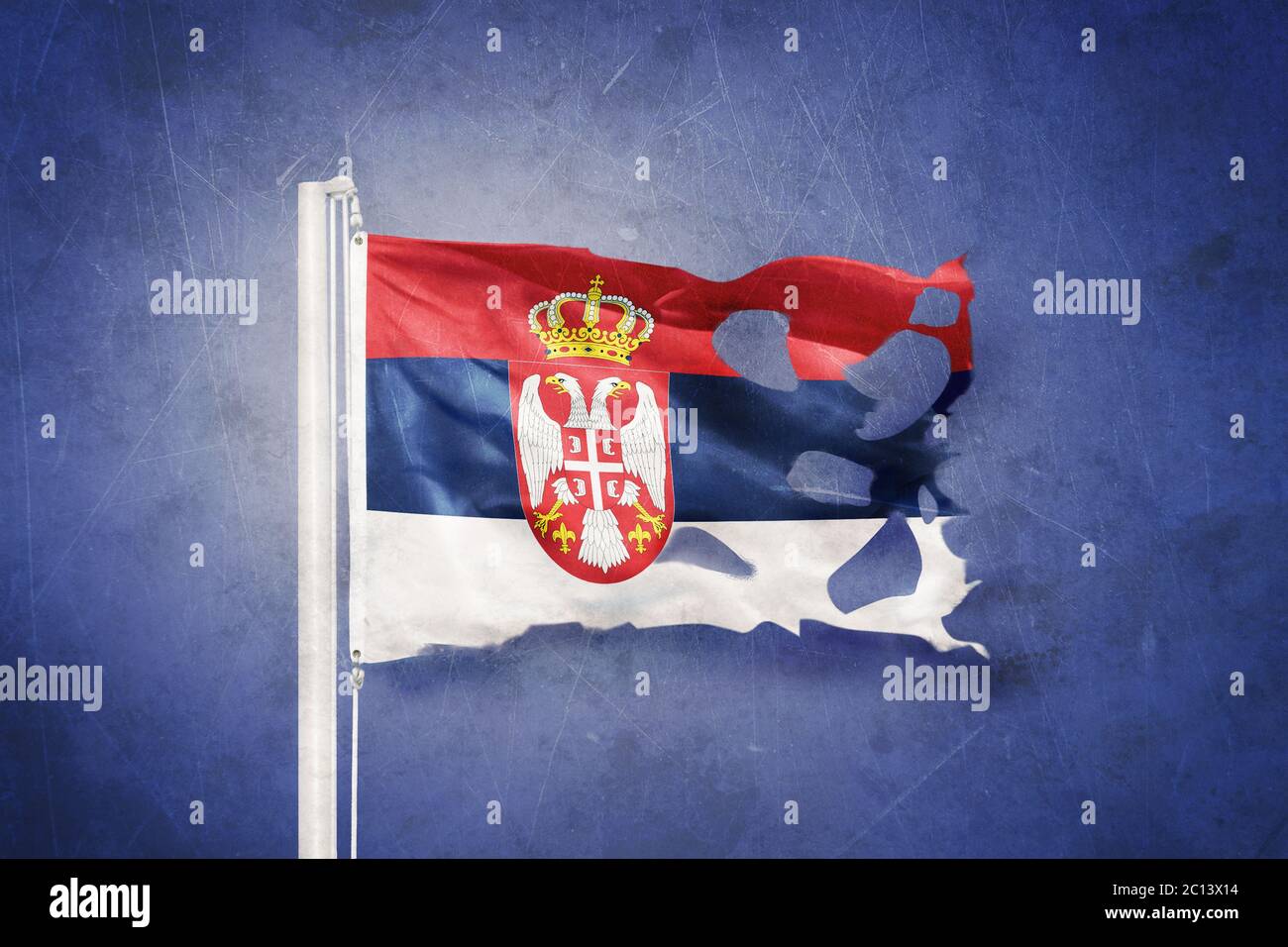 Torn flag of Serbia flying against grunge background Stock Photo