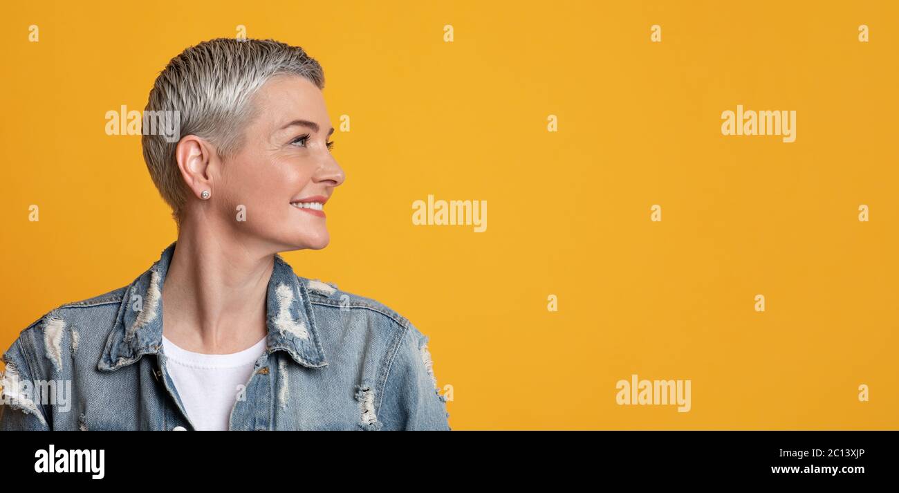 Nice Promo. Smiling Mature Lady Looking With Interest At Copy Space Stock Photo