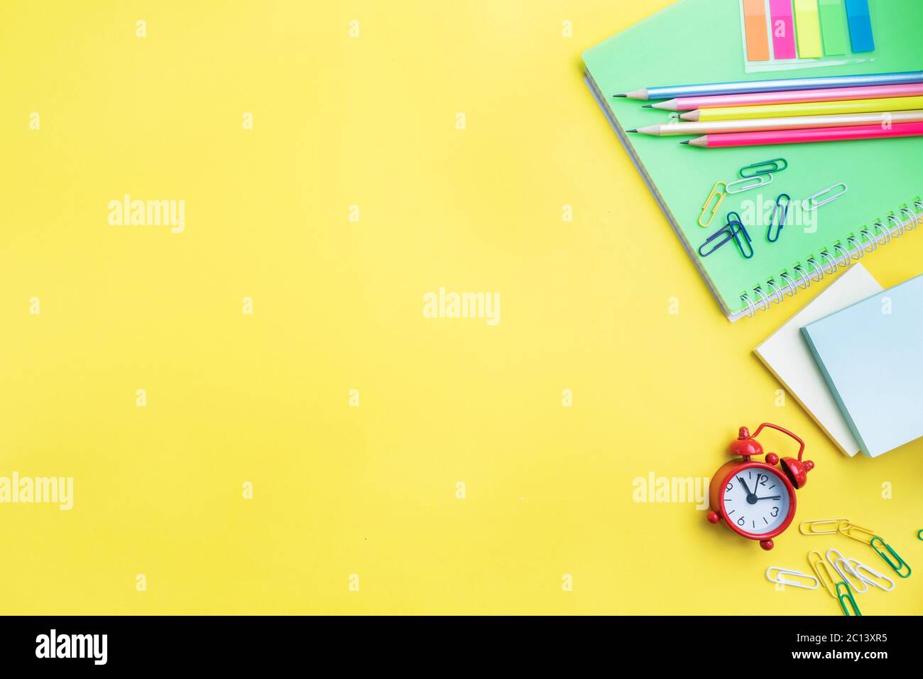 School supplies, notebooks pencils on yellow background with copy space Stock Photo