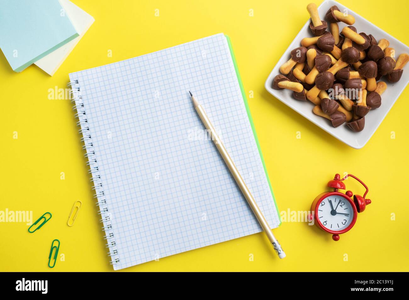 School supplies and cookies for a snack on the yellow table with copy space. concept school, Stock Photo