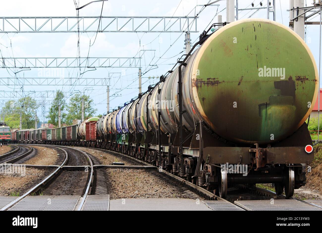a lot of colored cars on a freight train, which travels along the rails of the railway. Stock Photo