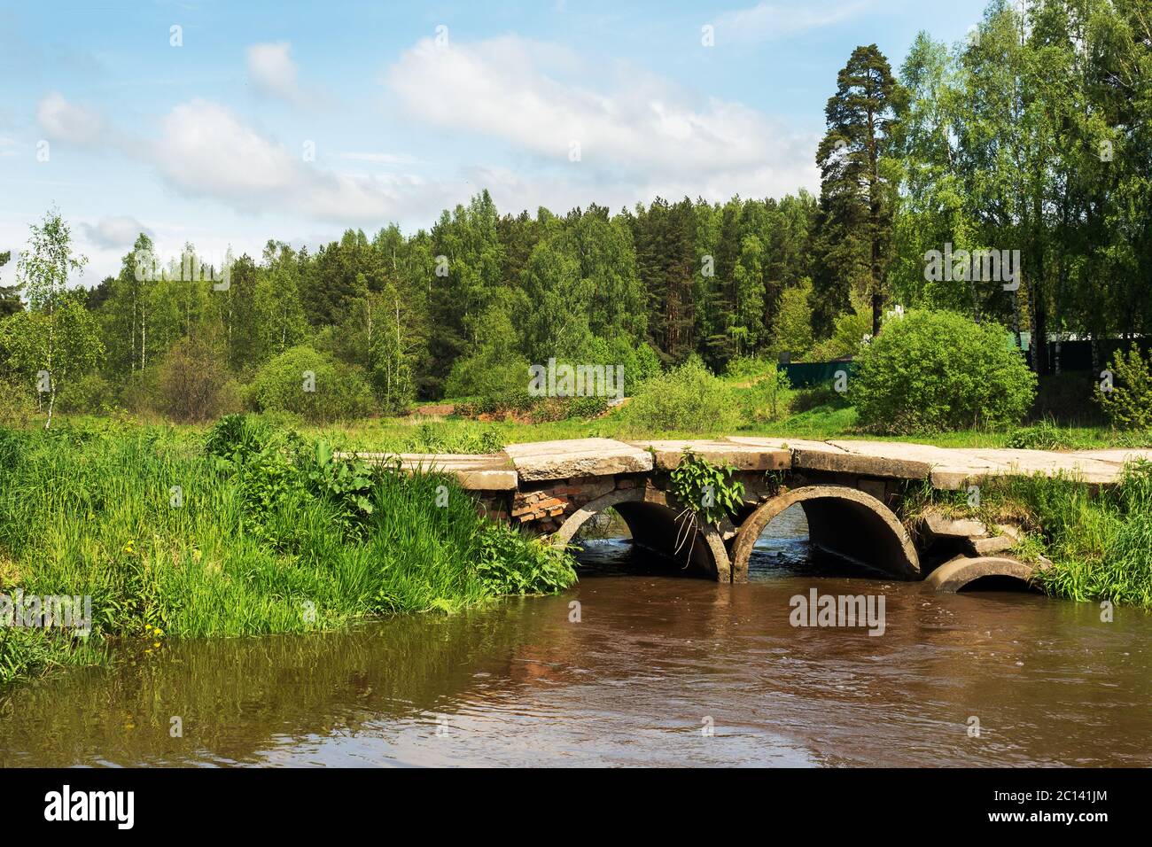View of the bridge over the forest river. Landscape of the river and bridge in the village. View of the forest on a summer day Stock Photo