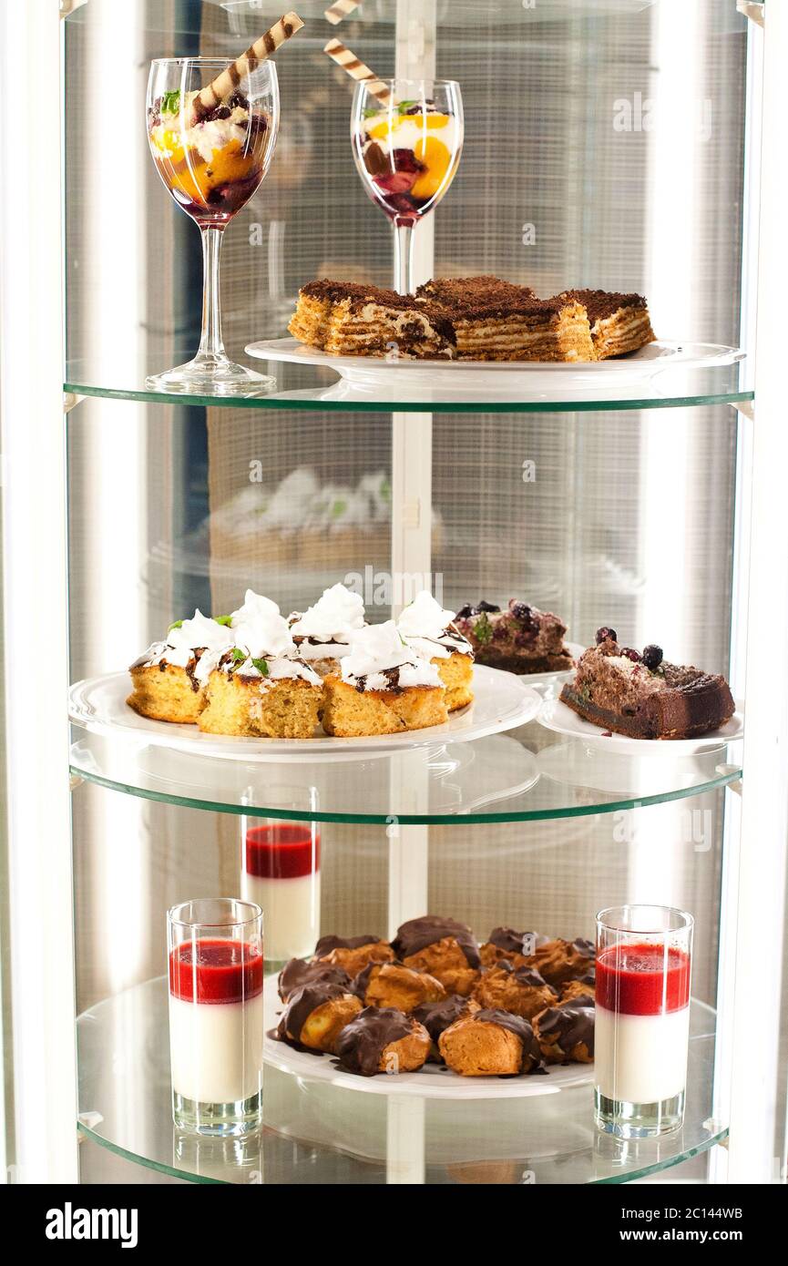 Refrigerator with various desserts on the shelves. Stock Photo