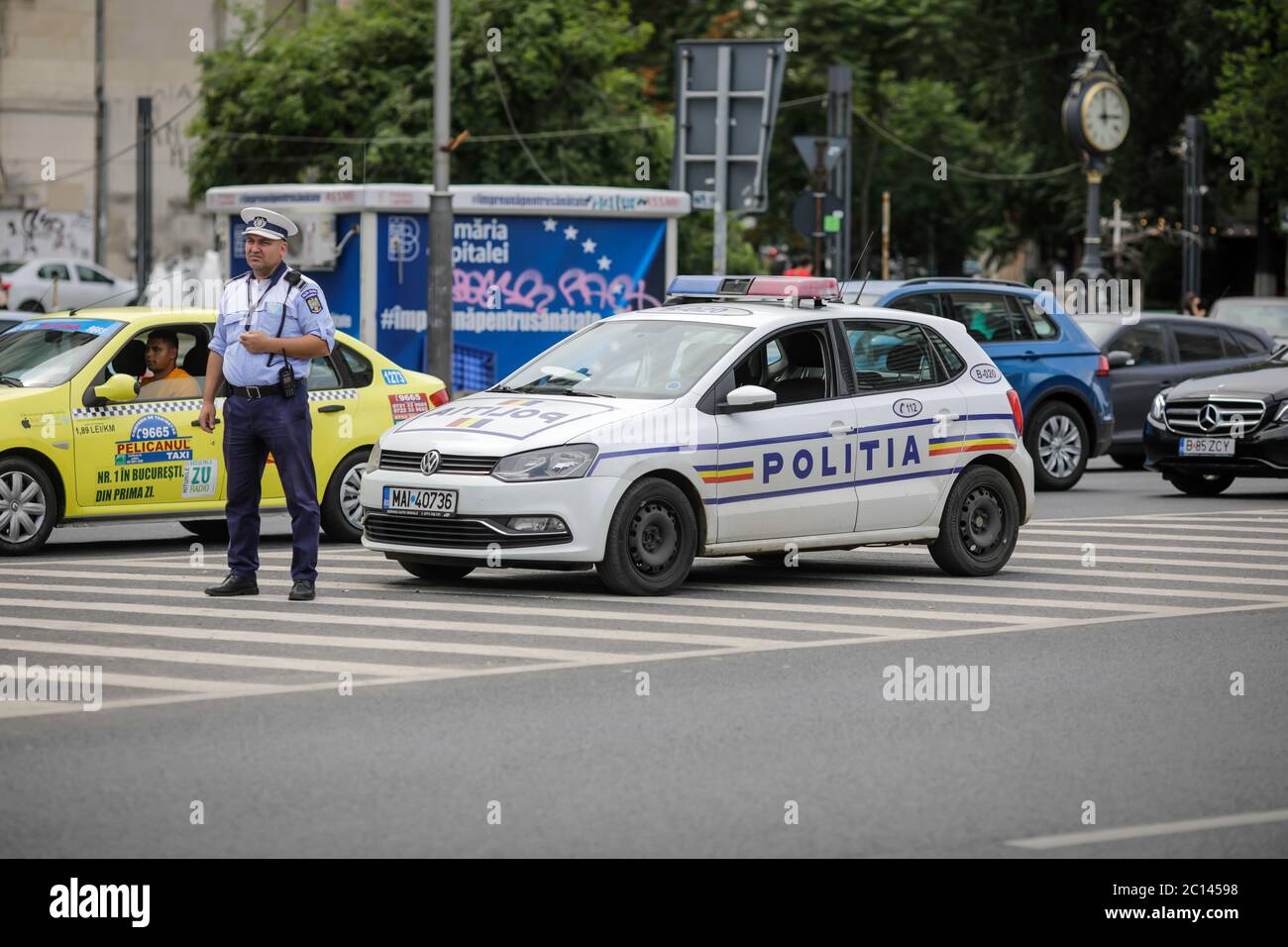 Bucharest, Romania - June 13, 2020: Romanian police officer near a police car in downtown Bucharest. Stock Photo