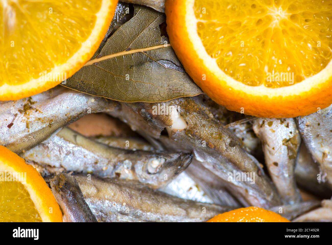 fried fish dish with sliced orange and bay leaf. selective focus macro shot with shallow DOF Stock Photo