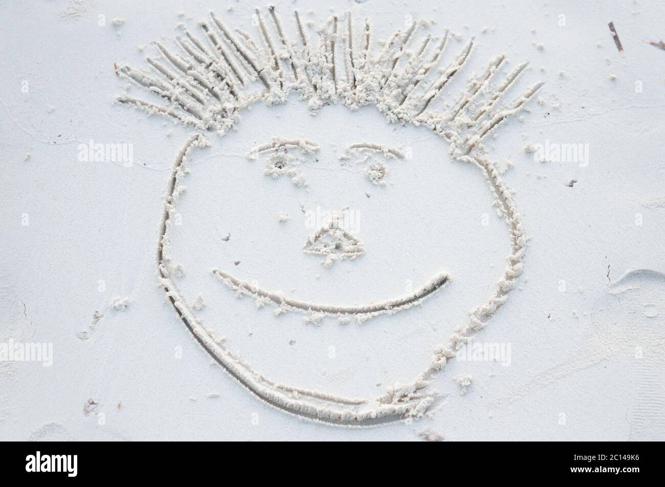 Funny smiley face drawn on white sand of Maldives Stock Photo