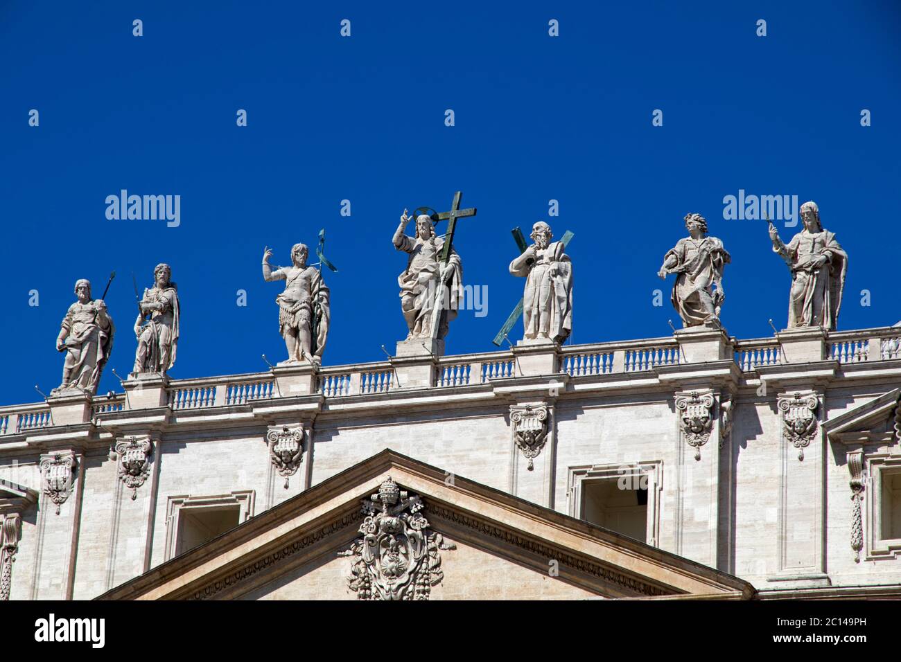 The facade of St Peter's Basilica in Rome featuring statues of Jesus ...