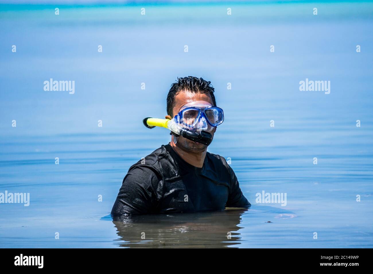 Indian man with snorkeling equipment in ocean water in the Maldives Stock Photo