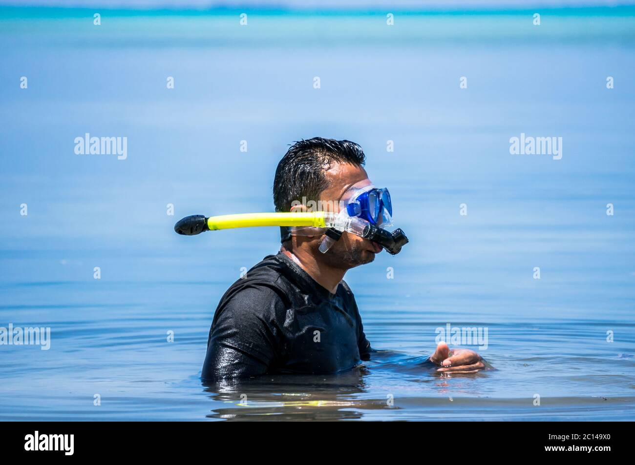 Indian man with snorkeling equipment in ocean water in the Maldives Stock Photo