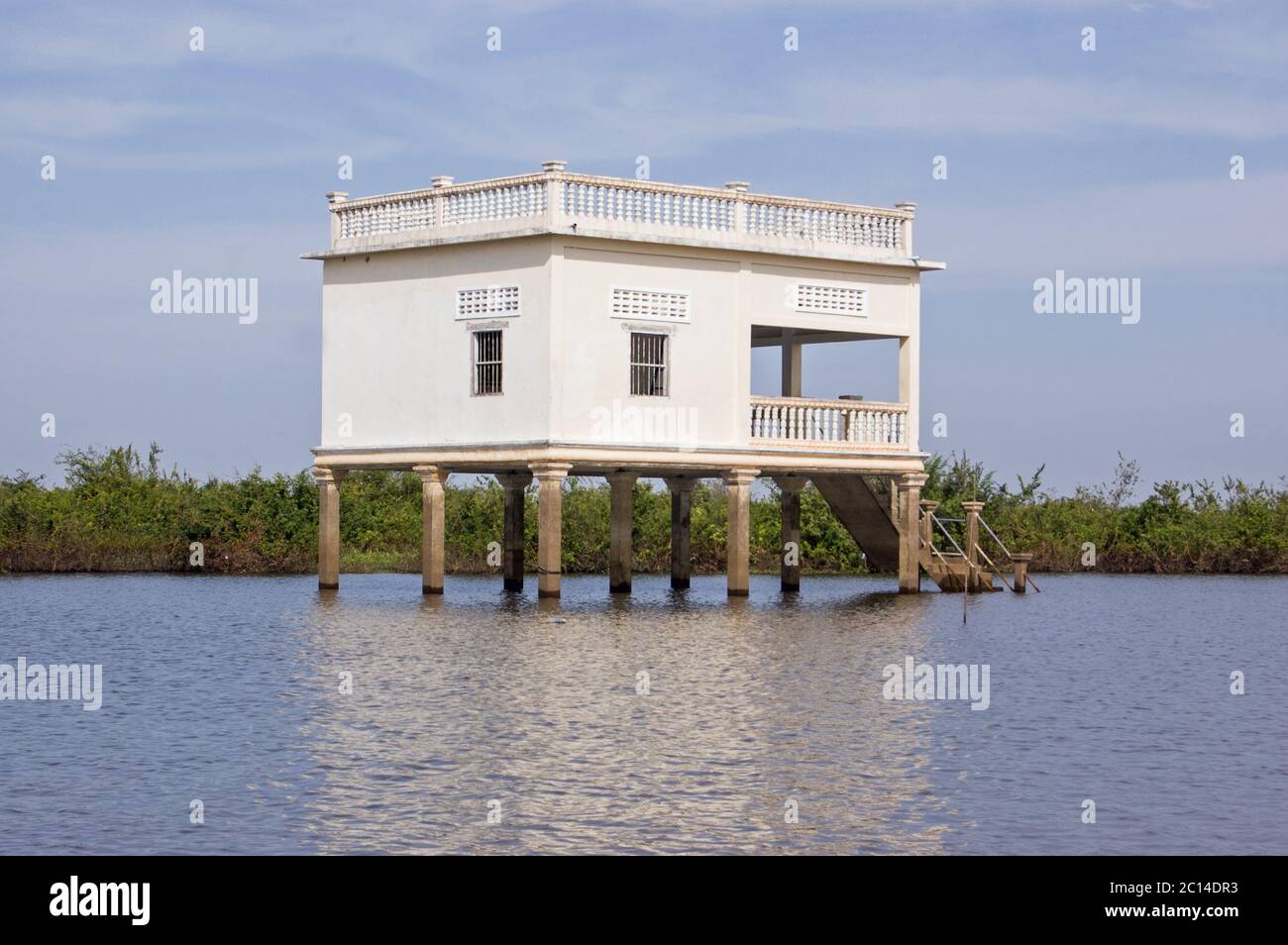A traditional stucco villa built high on stilts in the floating village of Kompong Phluk on the Tonle Sap lake, Cambodia. Stock Photo