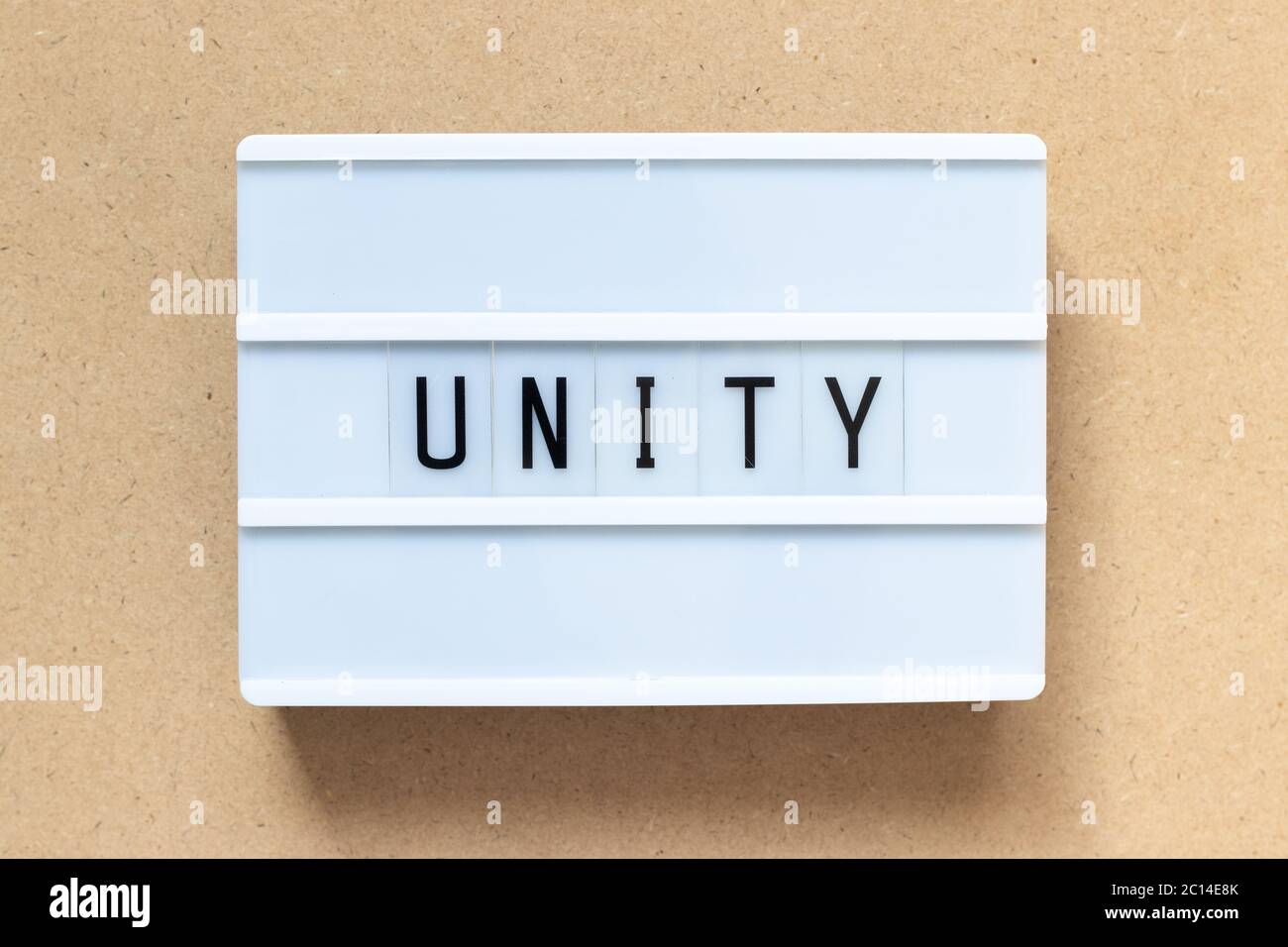 White lightbox with word unity on wood background Stock Photo