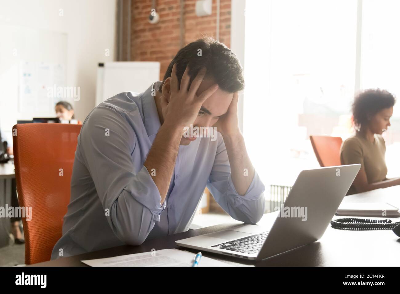 Unhappy businessman employee receive bad news, holding head in hands Stock Photo