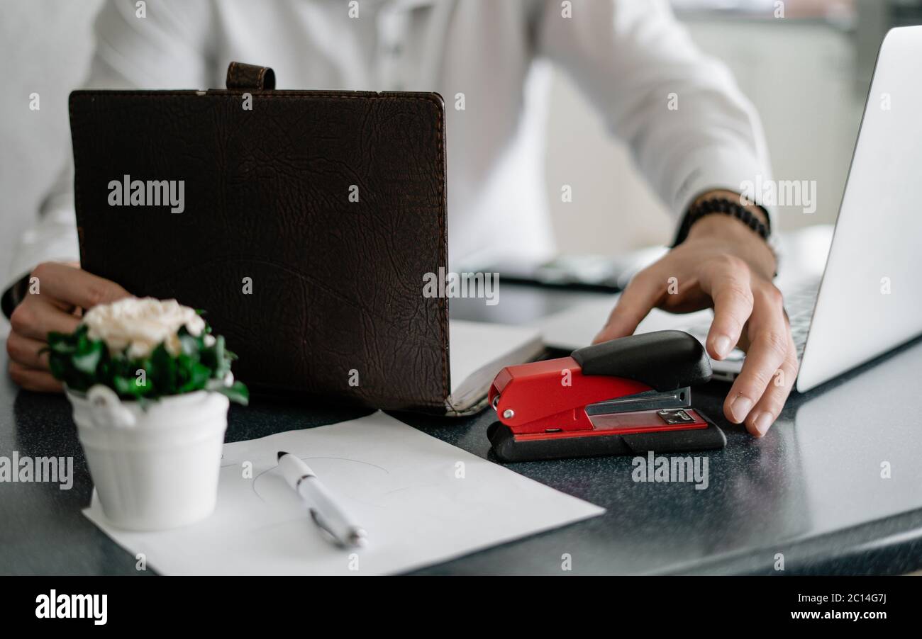 Businessman in home office holding stapler and documents isolated on white background. Professional using laptop and smart phone in the office Stock Photo