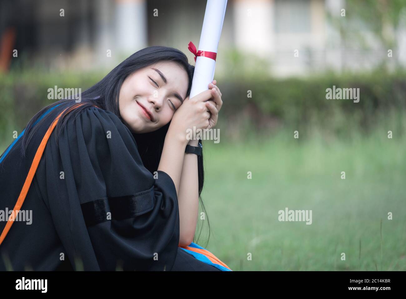 Portrait of happy and excited of young Asian female university graduate ...