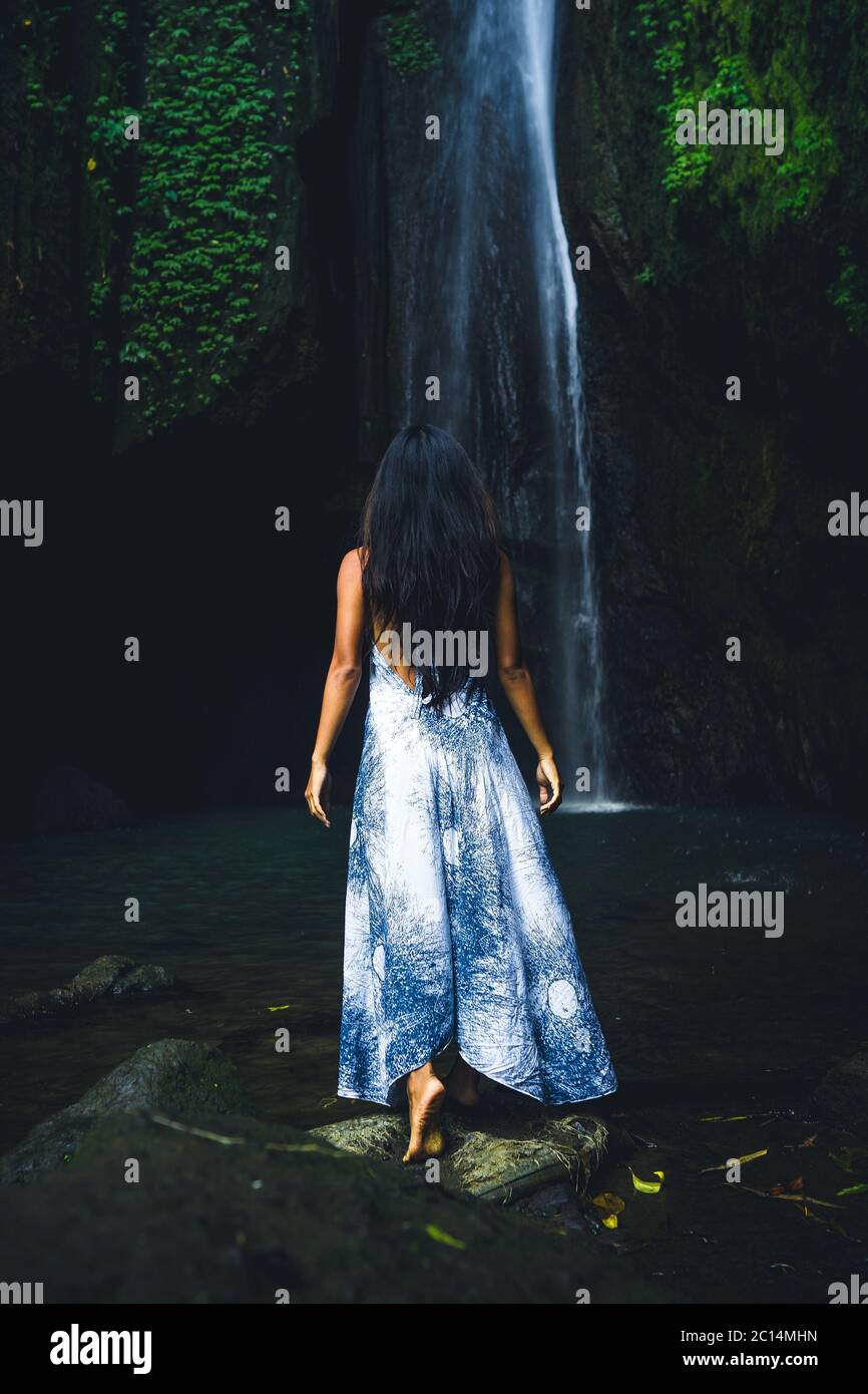 A woman meditates in nature. Meditation at the waterfall. Young woman ...